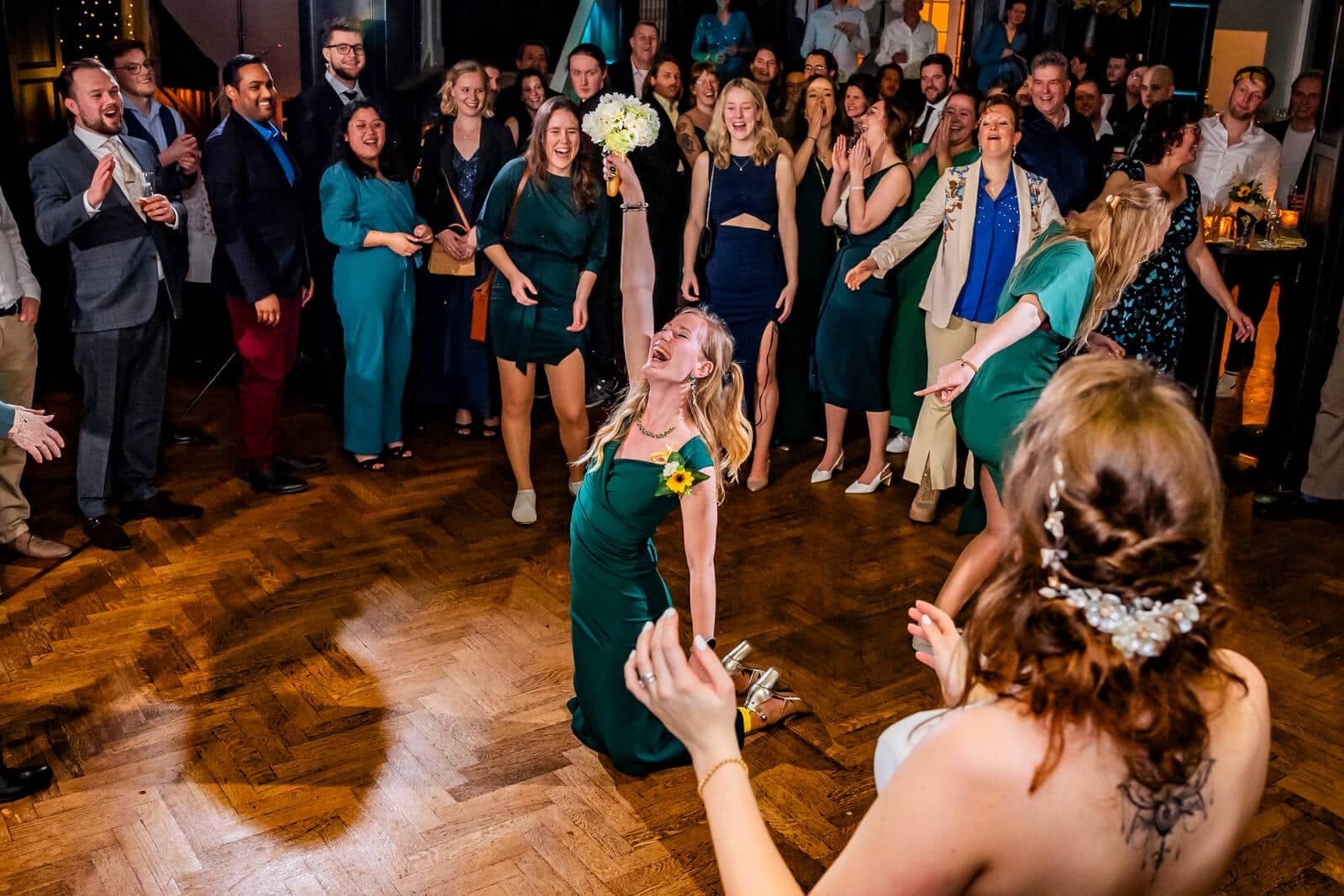 Guests watch intently as the bouquet flies through the air
