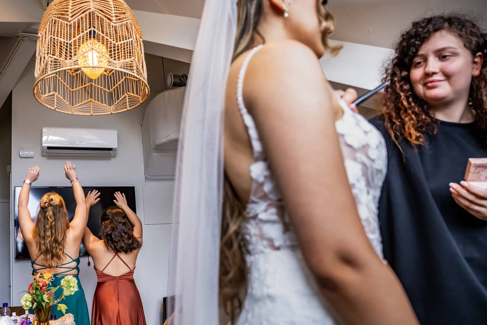 In the background two friends stretch against the wall, in front the bride gets ready