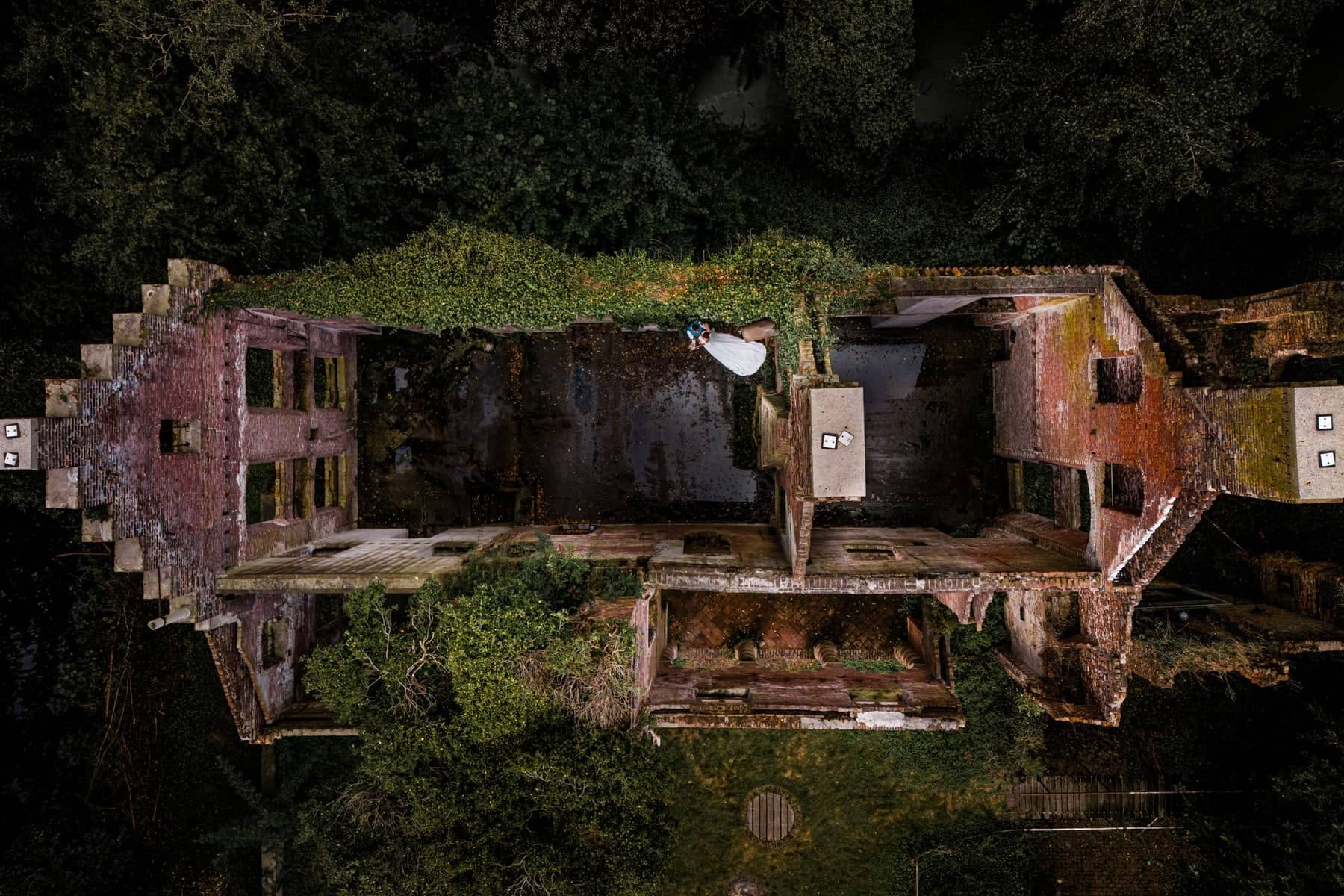 Drone shot from above: a couple on the wall of an overgrown ruin