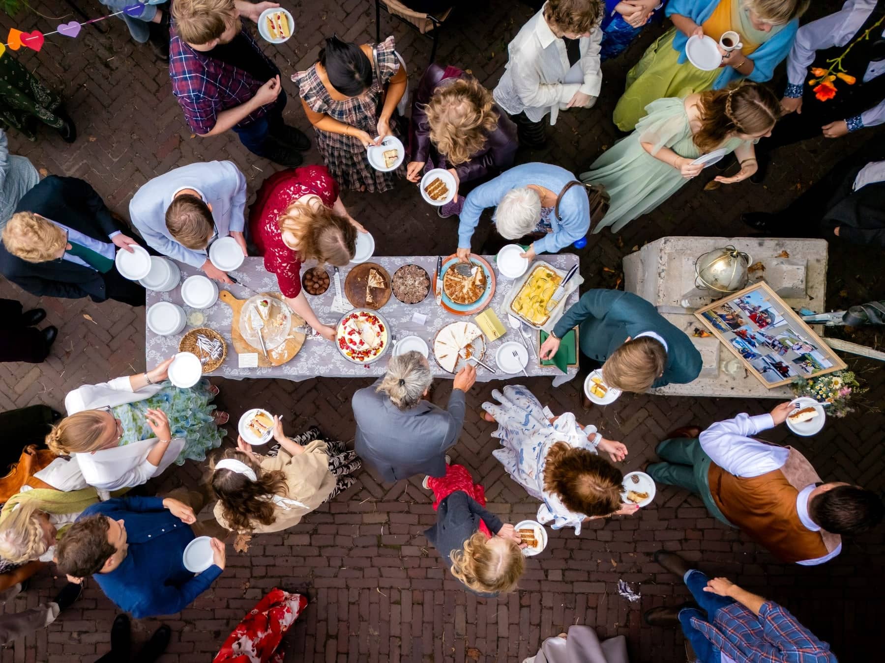 Drone shot of guests around a cake buffet in a courtyard