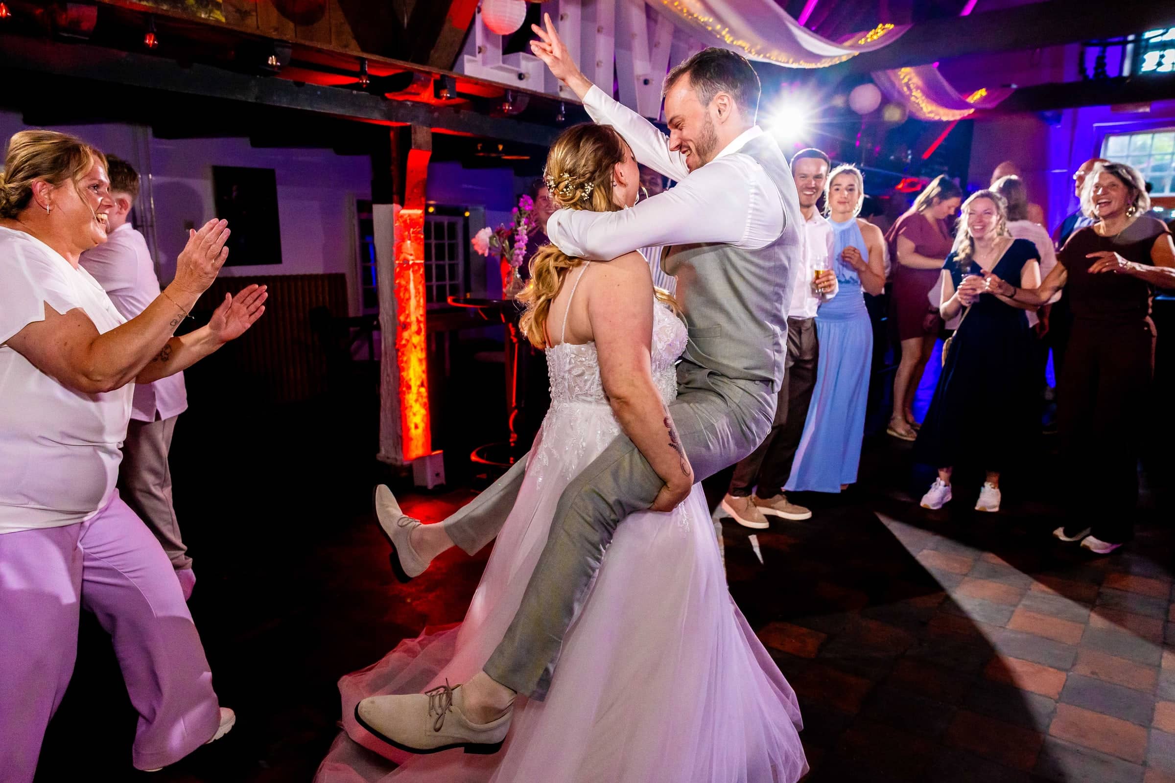 At the party the groom jumps into the bride’s arms