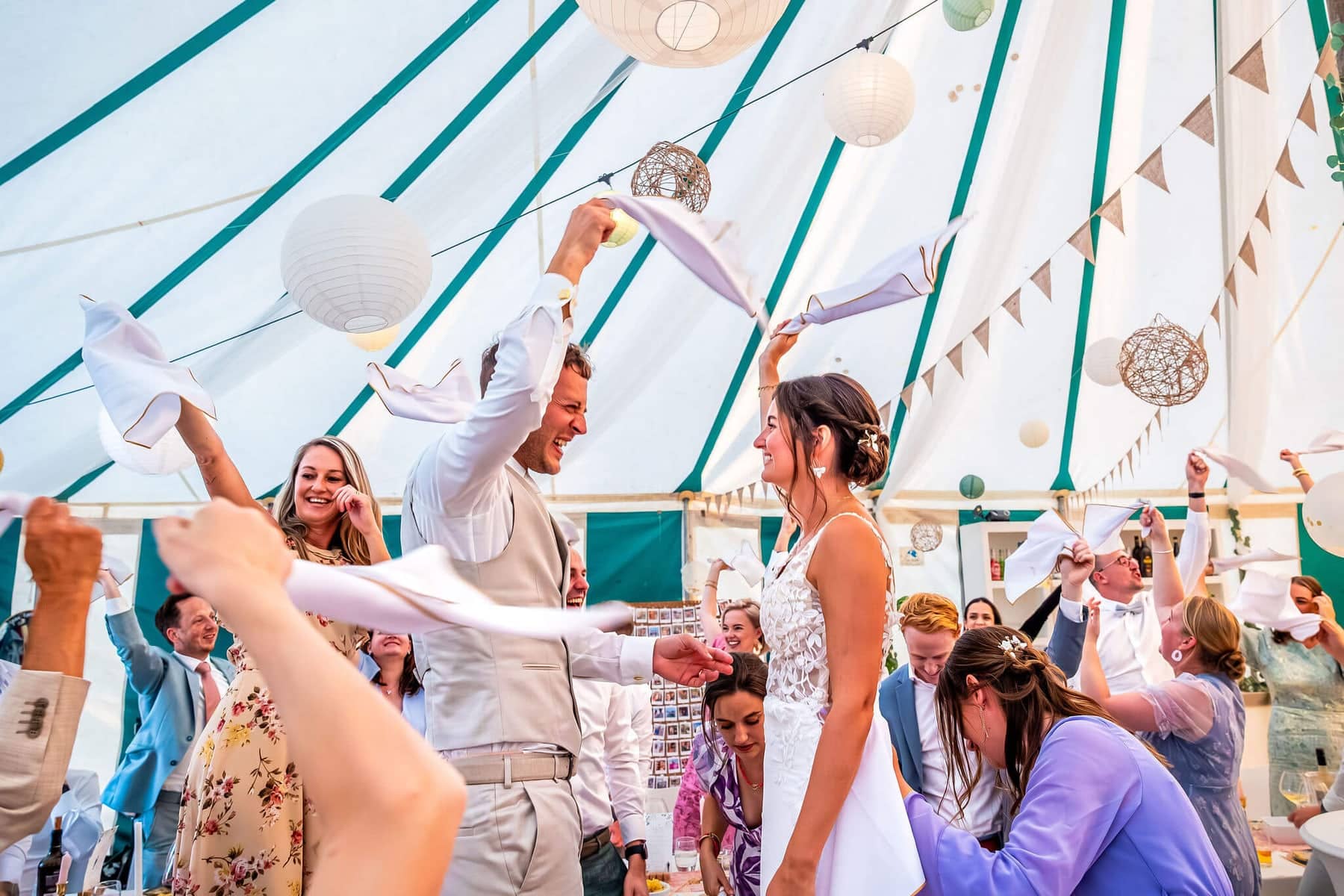 Guests wave napkins as the couple enter the marquee