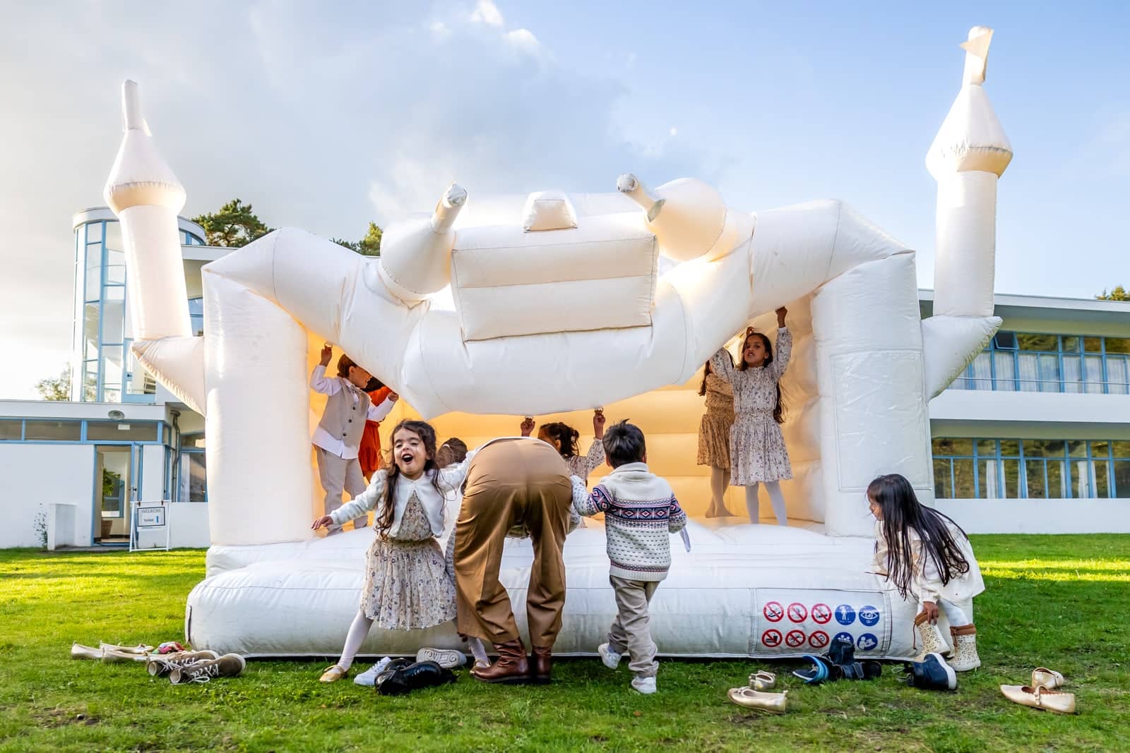Children bounce on a white castle-shaped bouncy castle