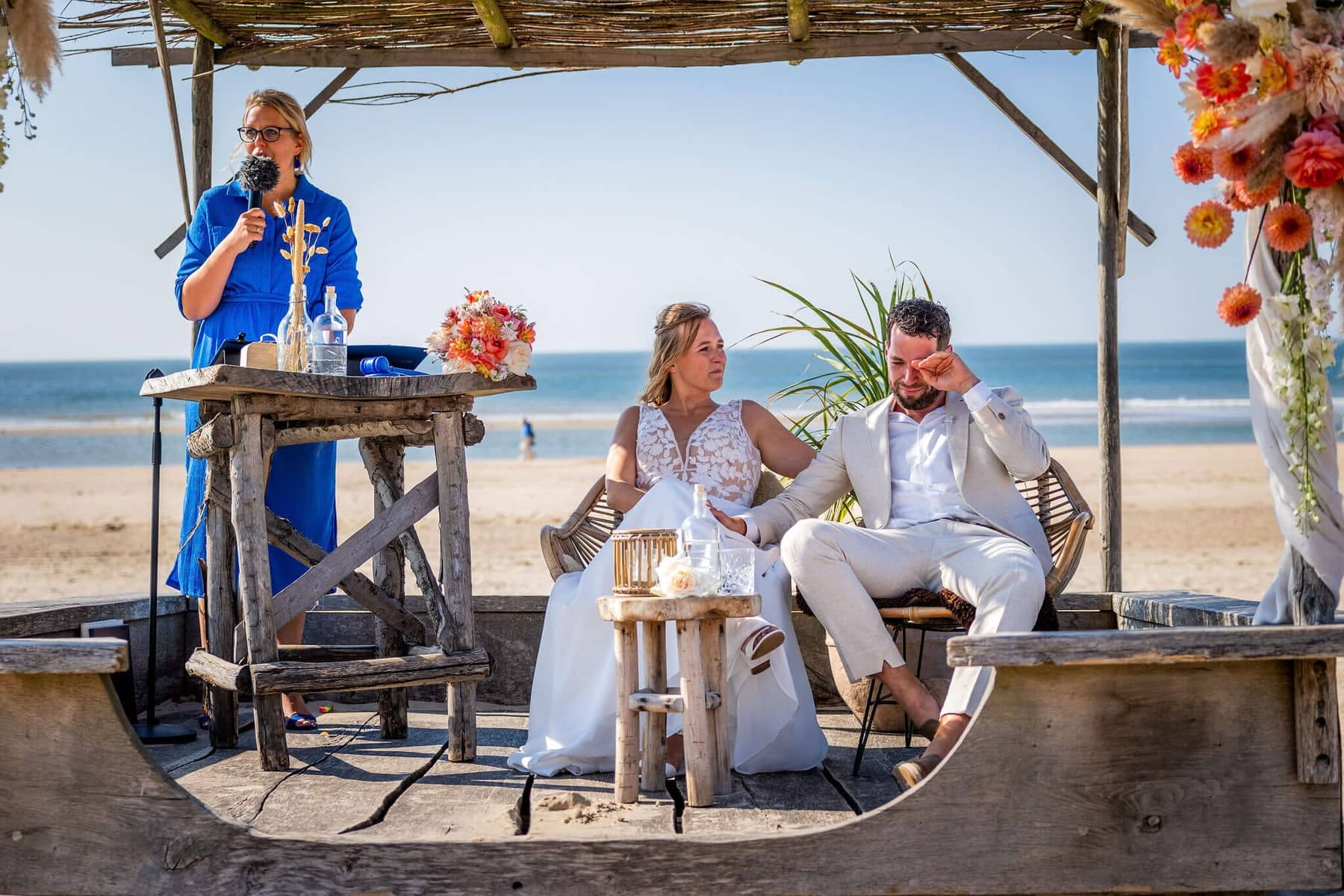 Beach ceremony: the groom wipes away a tear as the officiant speaks