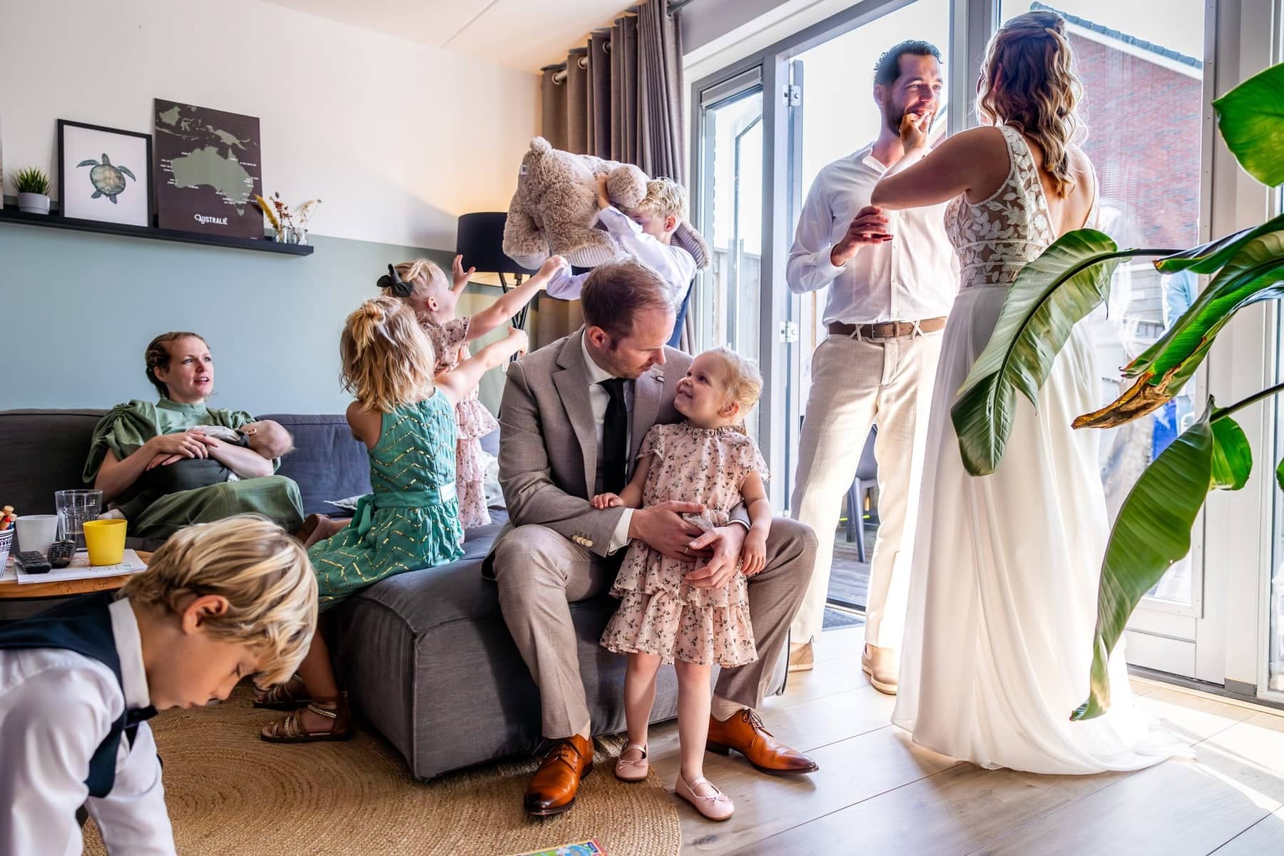 Getting ready at home: children play with cuddly toys in the living room while the couple gets ready