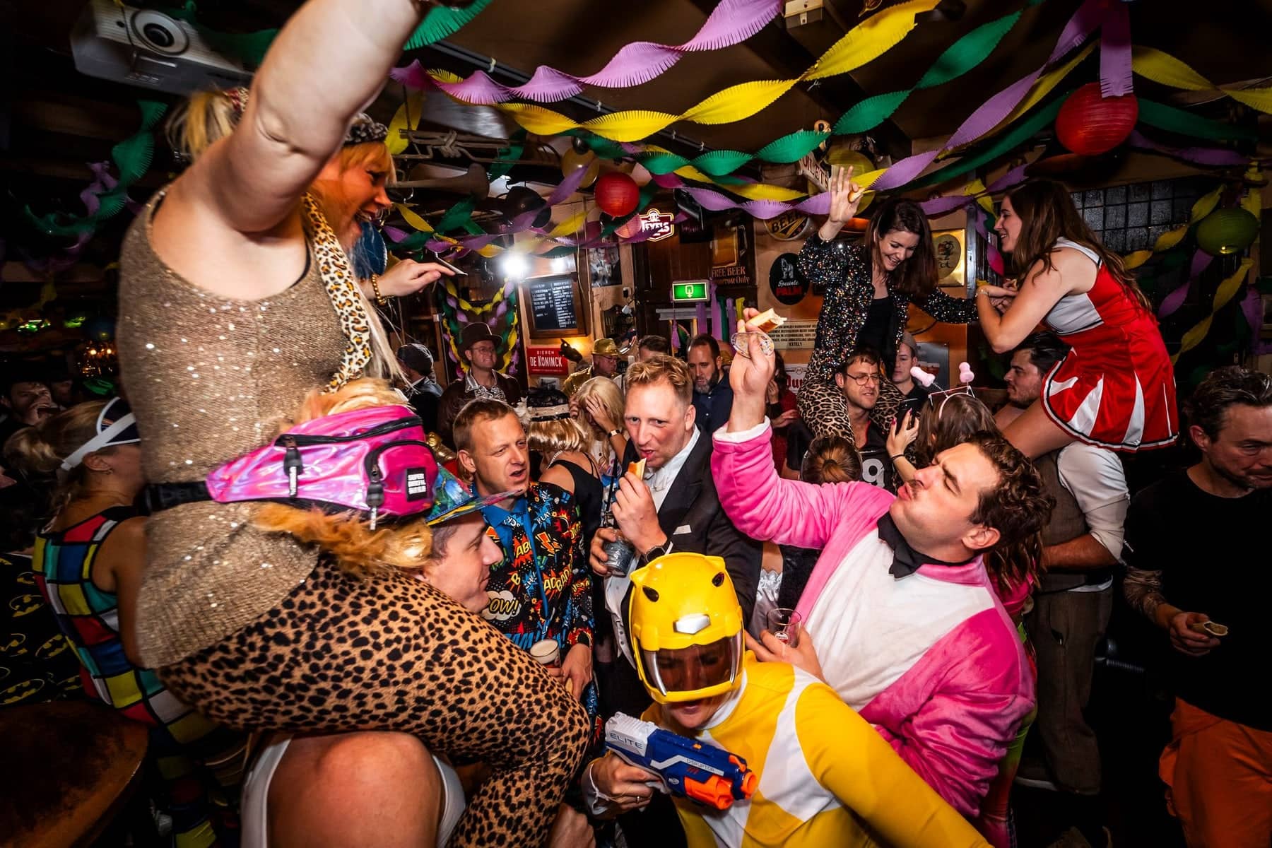 Fancy-dress party in a pub full of streamers: guests in leopard print and superhero suits go wild