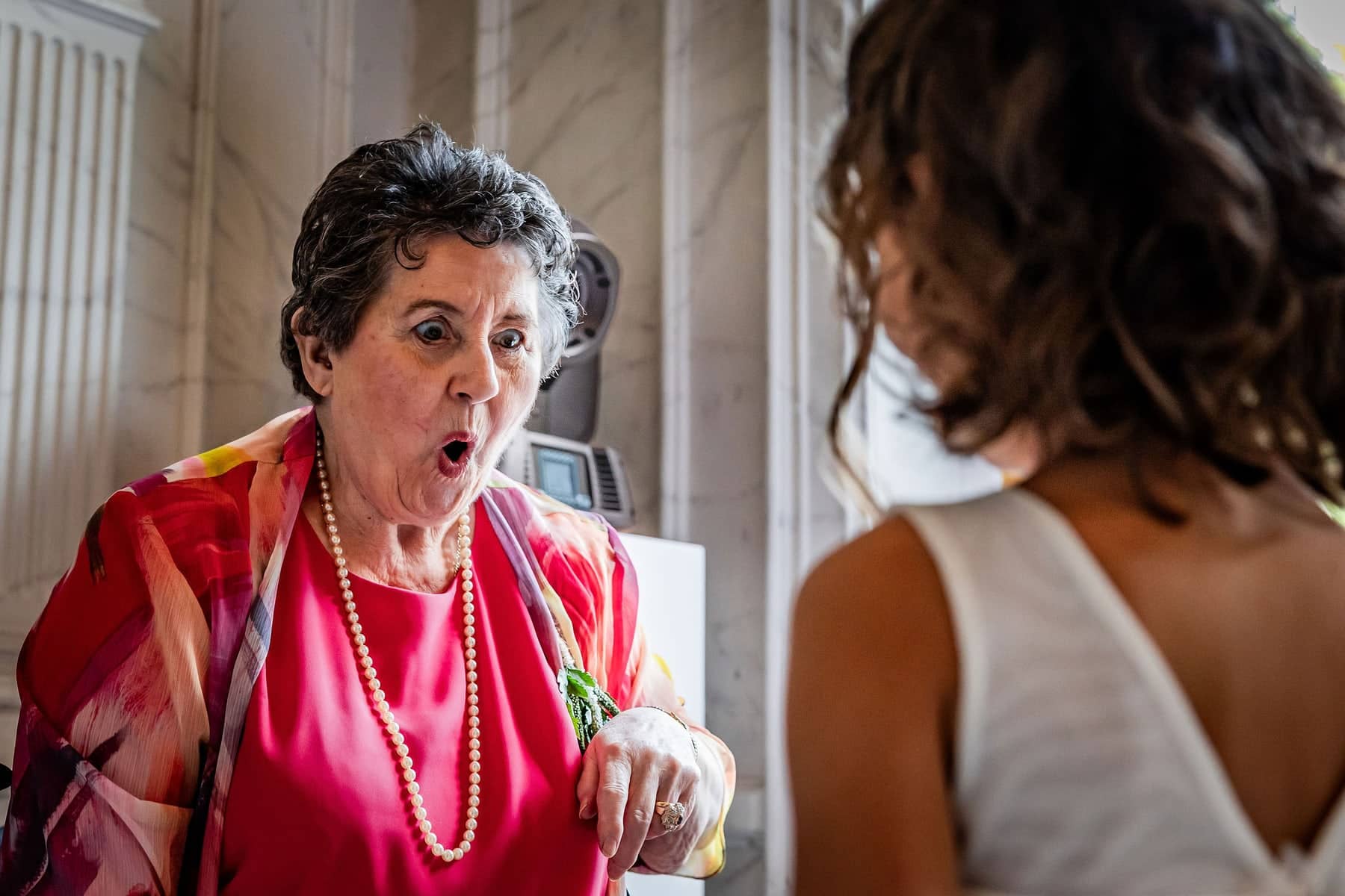 A grandmother looks at the bride in utter surprise
