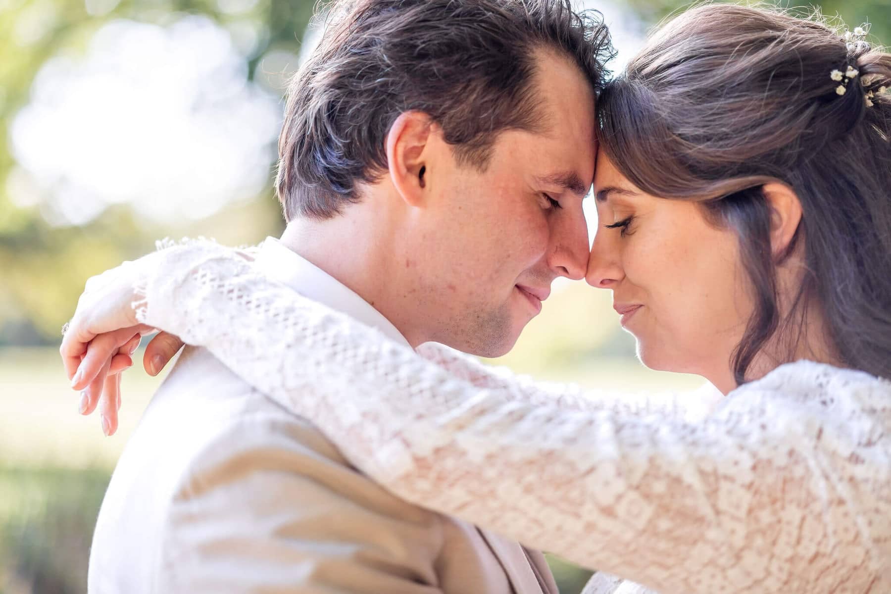 Couple resting their foreheads together in soft backlight