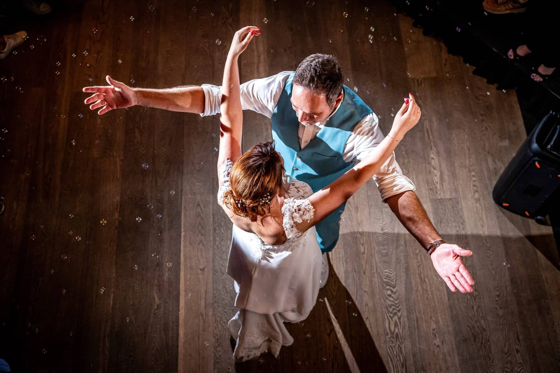 From above: the couple dances among soap bubbles on a wooden floor